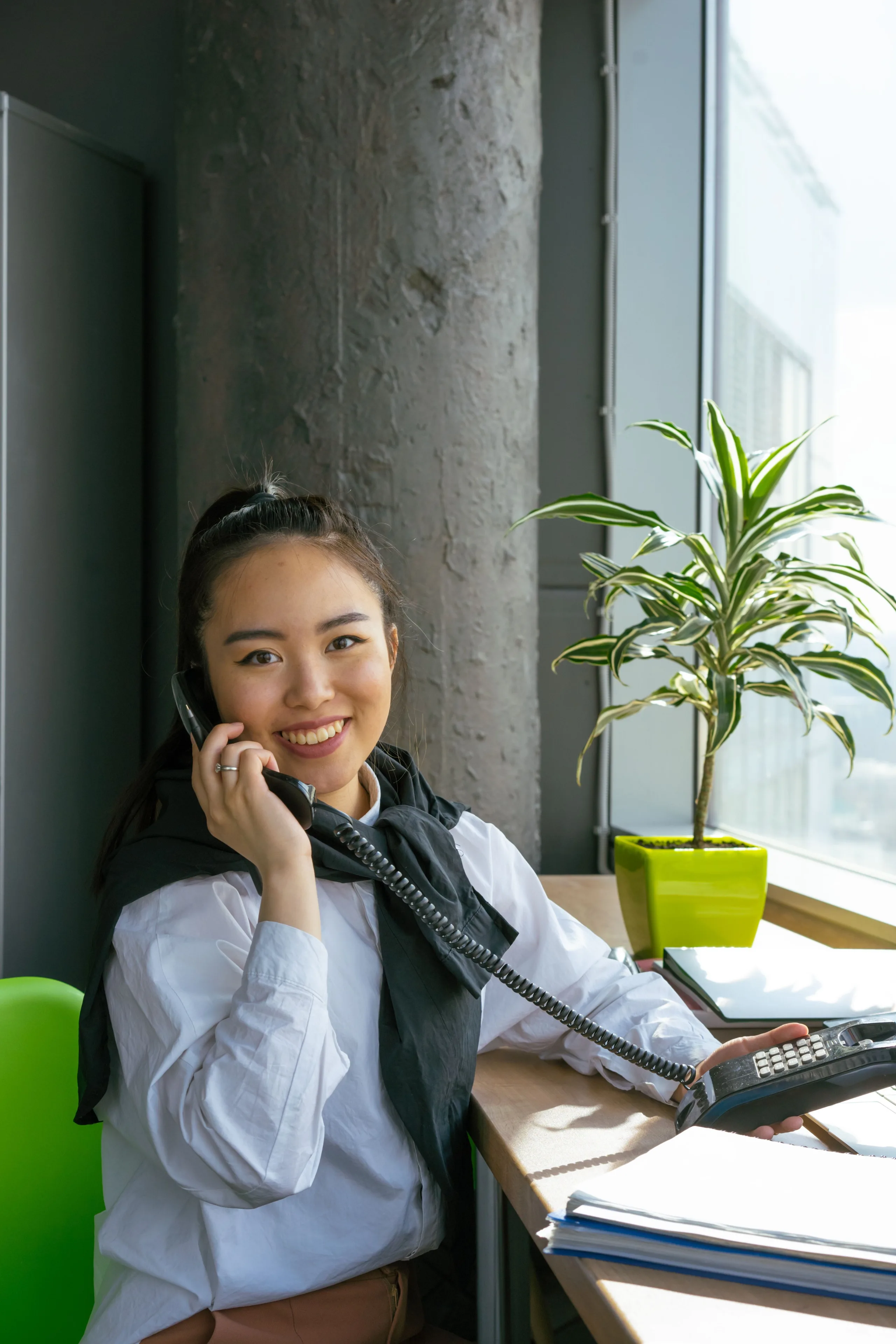 A FigsFlow migration lead at her desk by the window, taking a first call with a Canadian firm about moving across