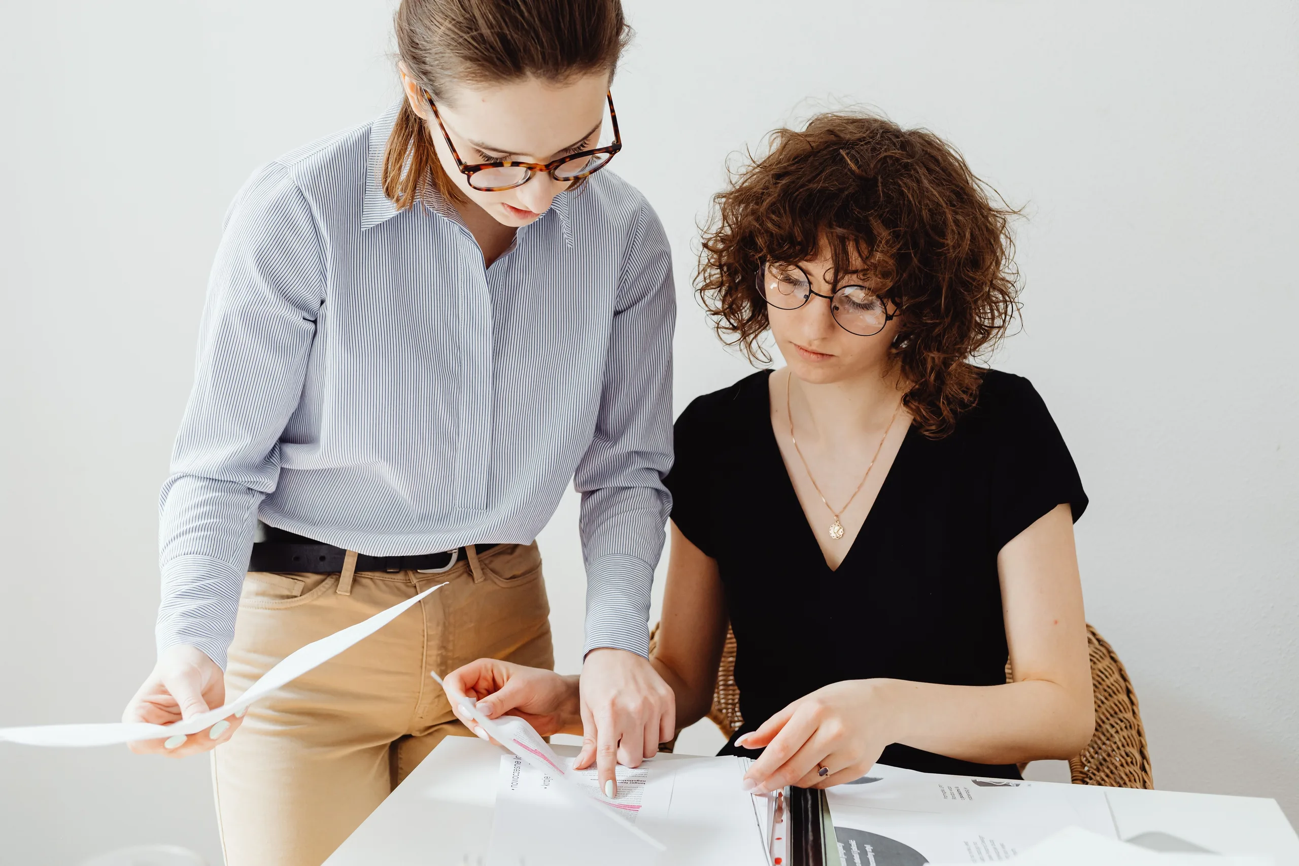 A bookkeeper and a client reviewing the month's figures together in an office