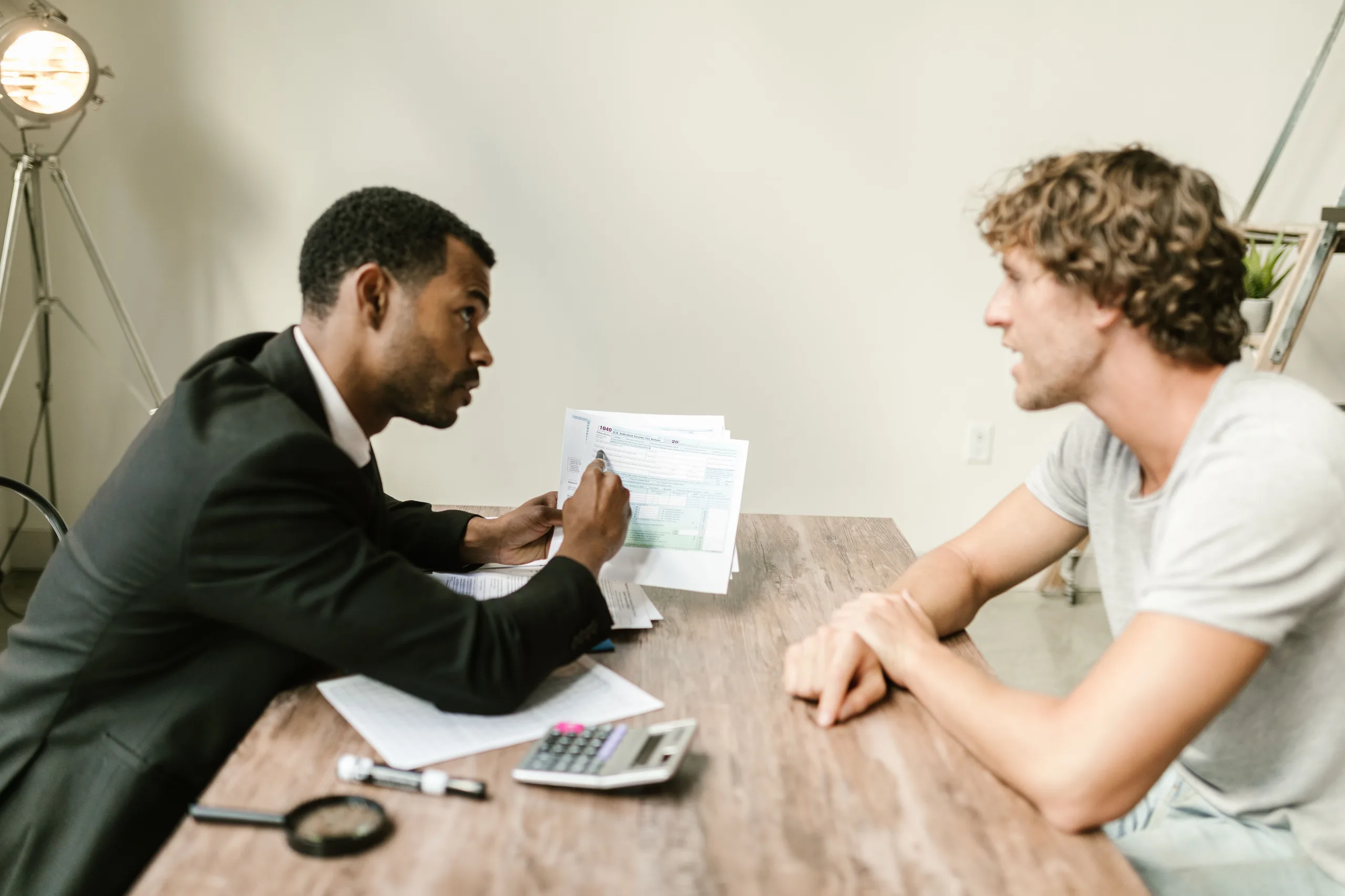 An accountant going through paperwork with a client across a desk