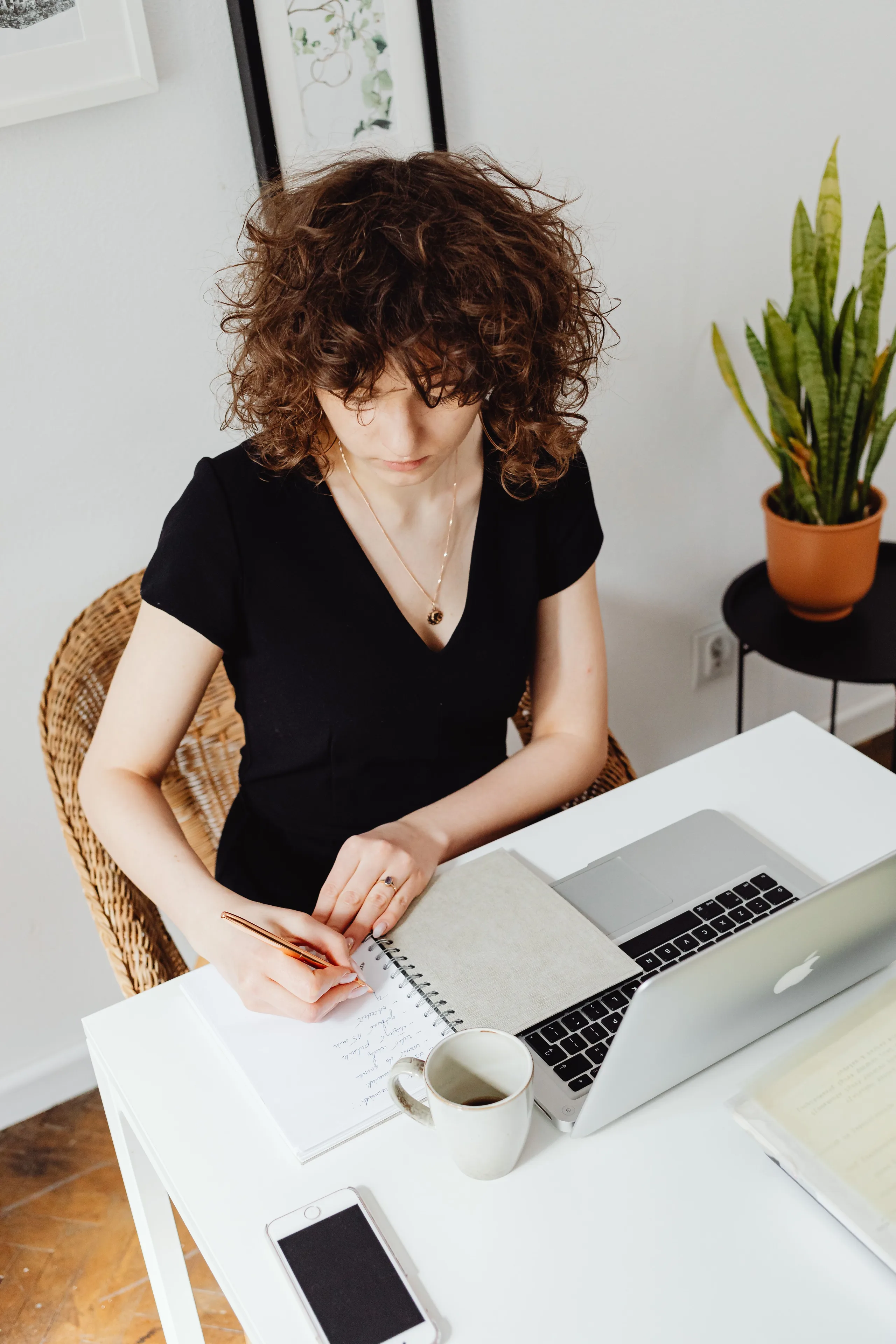 An accountant working alone at a desk in the early evening, laptop open, notes beside it