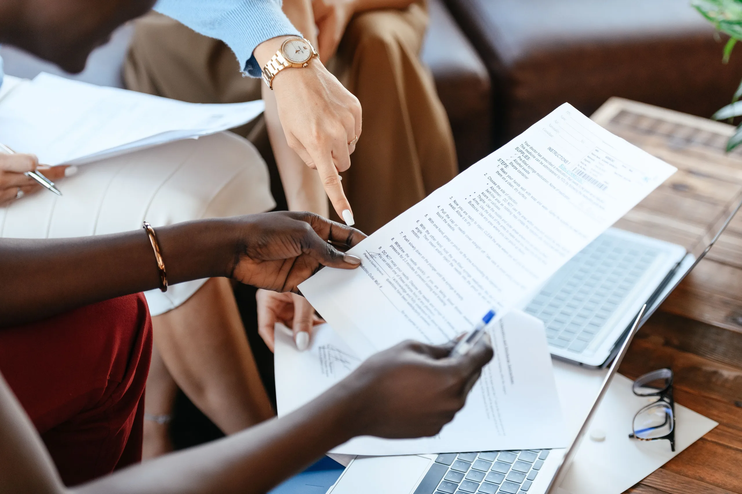 Colleagues reviewing company paperwork together around an office table