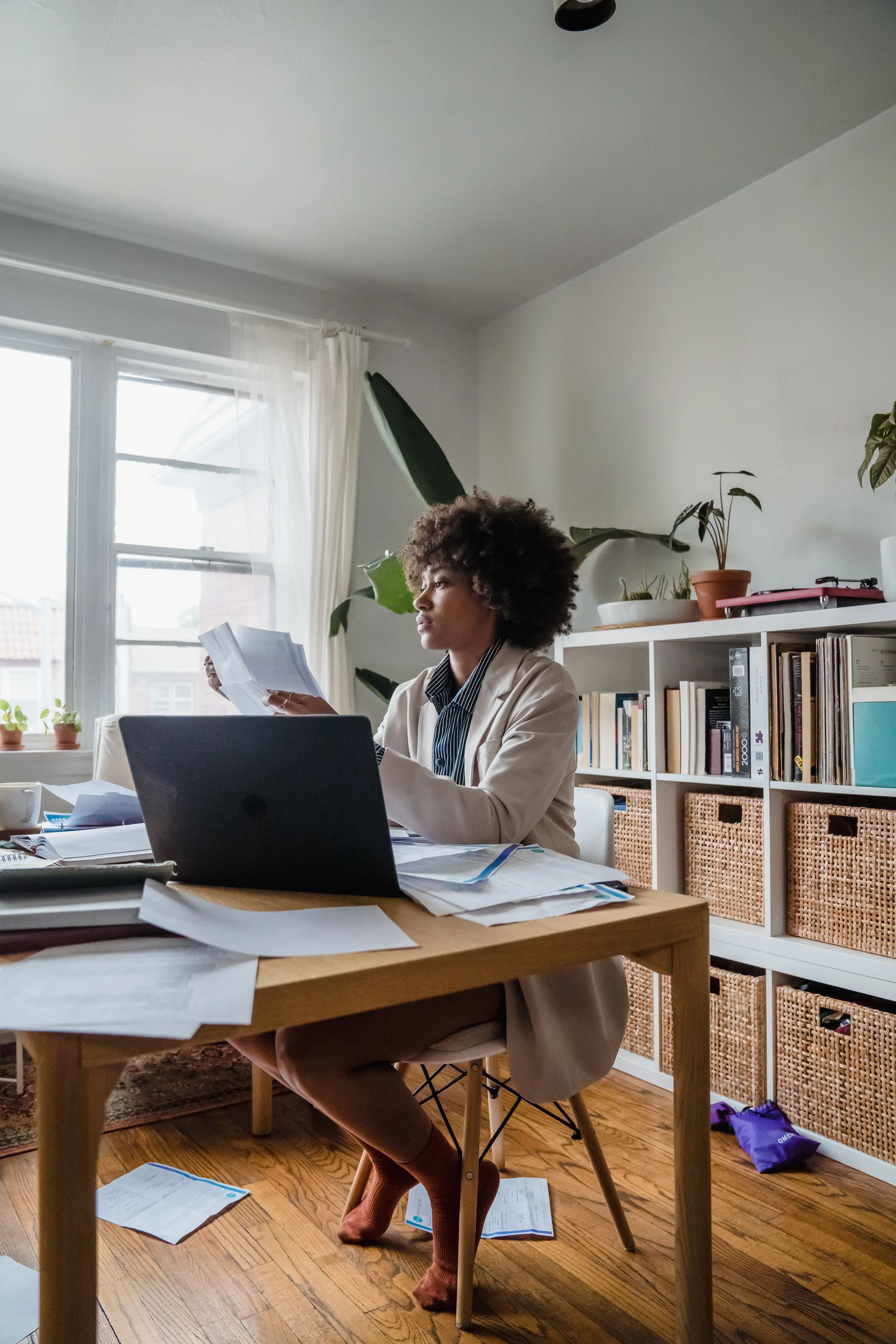 Director reviewing company documents at a home office desk in natural light
